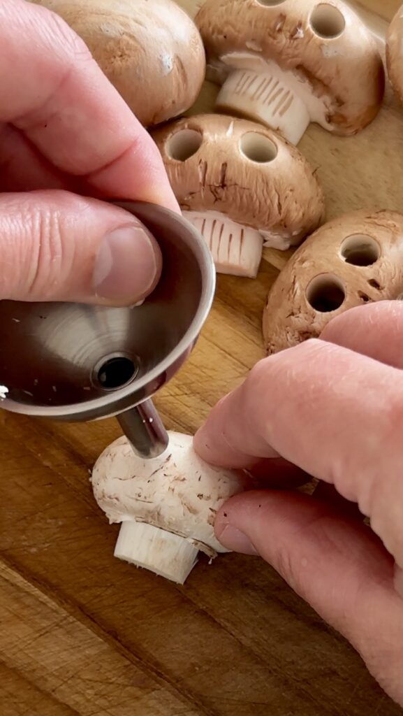 Using a metal spout or straw to punch eye sockets into a mushroom skull