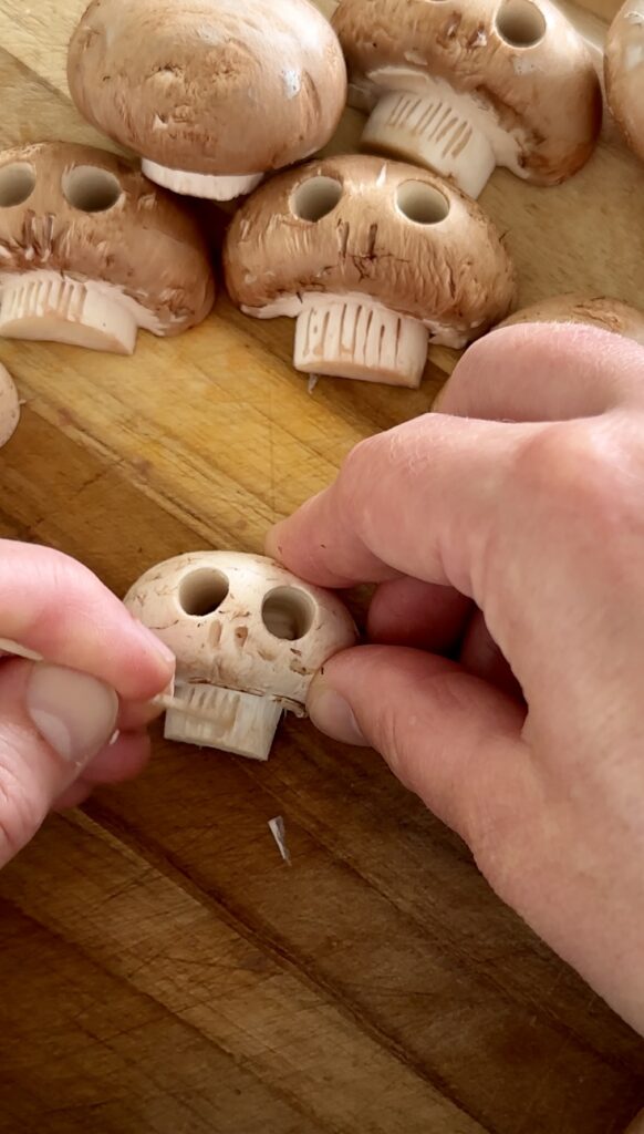 Using a wooden toothpick or skewer to score teeth details onto a mushroom stem for Halloween risotto by Chef Jen