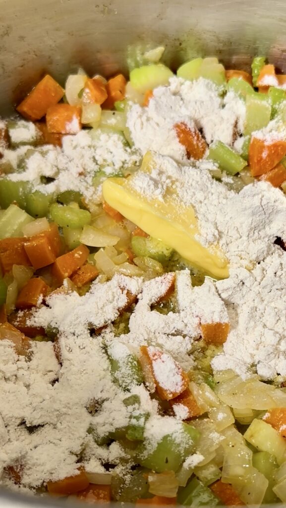 Stirring flour and butter into sautéed vegetables to make a soup roux