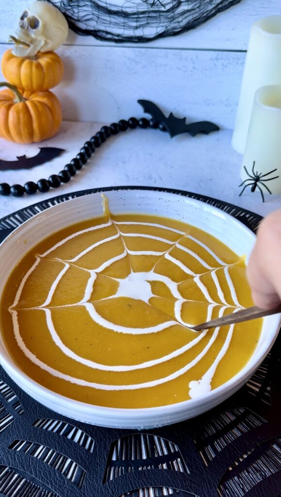 Using a chopstick or skewer drag lines from the center cream out to the edge of the bowl to create a spiderweb pattern garnish.